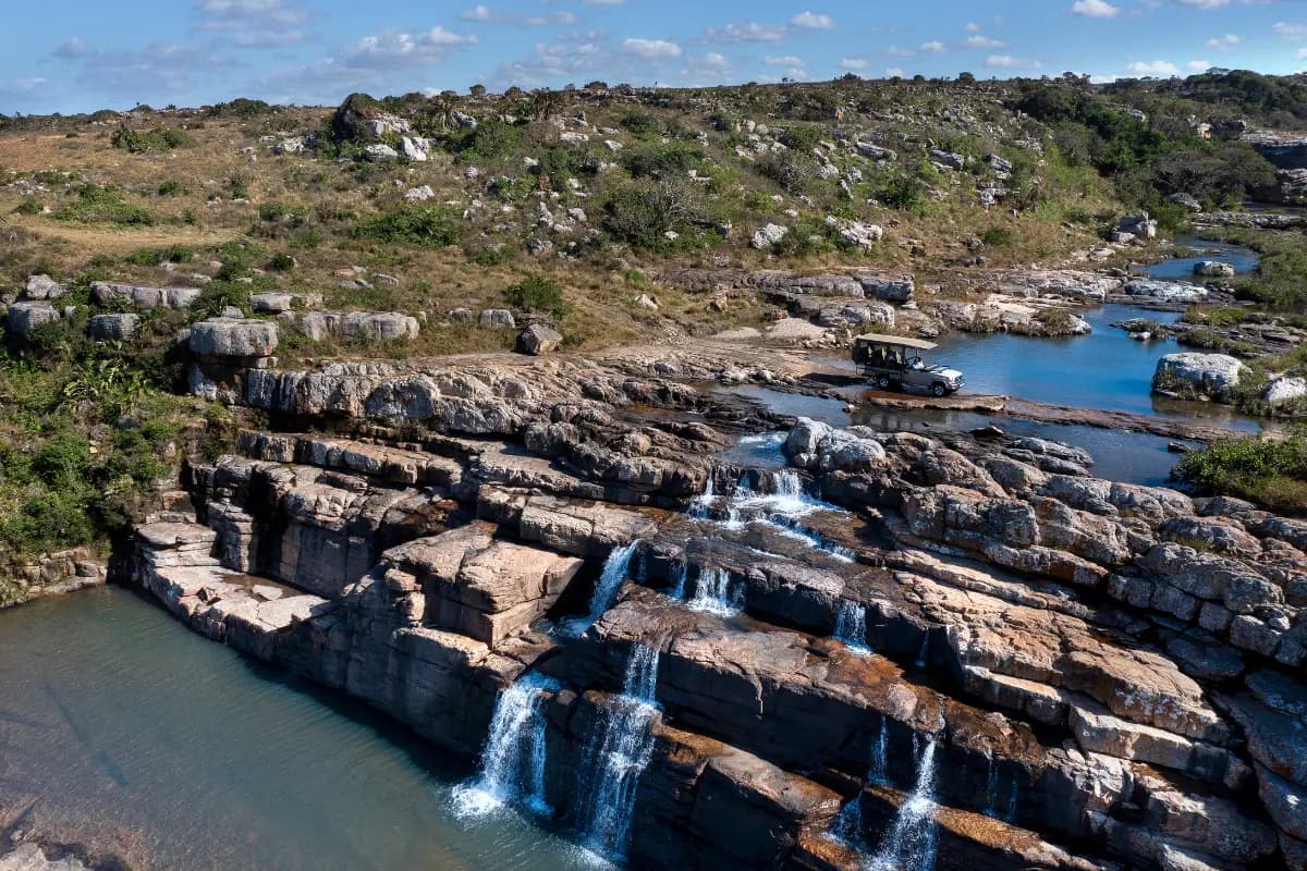 Aerial drone view of Horseshoe Falls cascading over sandstone rock shelves in Mkambathi Nature Reserve, Wild Coast