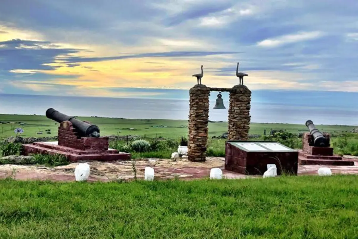 São Bento shipwreck monument with cannons and bell on Wild Coast headland overlooking the Indian Ocean at sunset