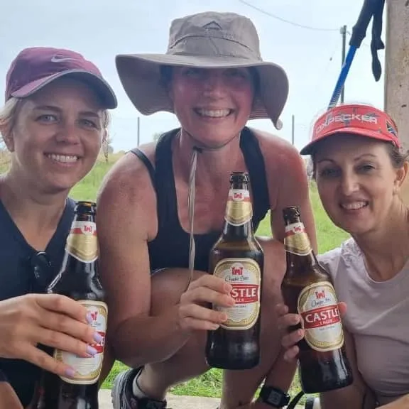 Three hikers celebrating with Castle Lager beers near Kwatengadusi beach on the Wild Coast