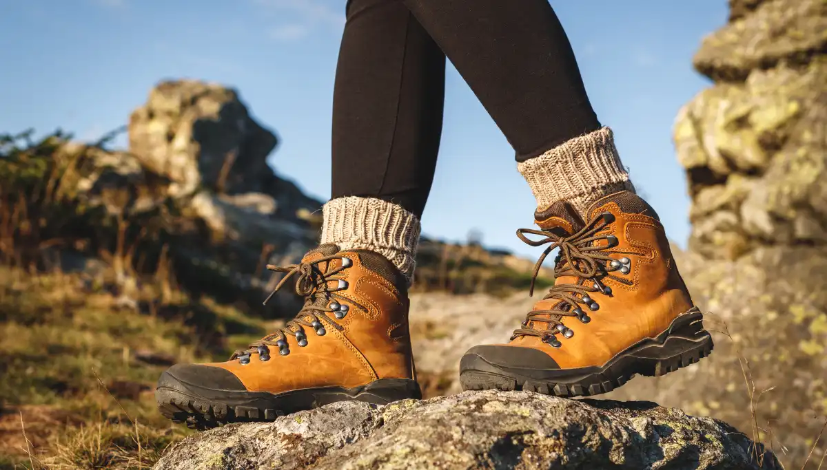 Close-up of sturdy leather hiking boots on rocky ground, essential footwear for multi-day South Africa trail hiking
