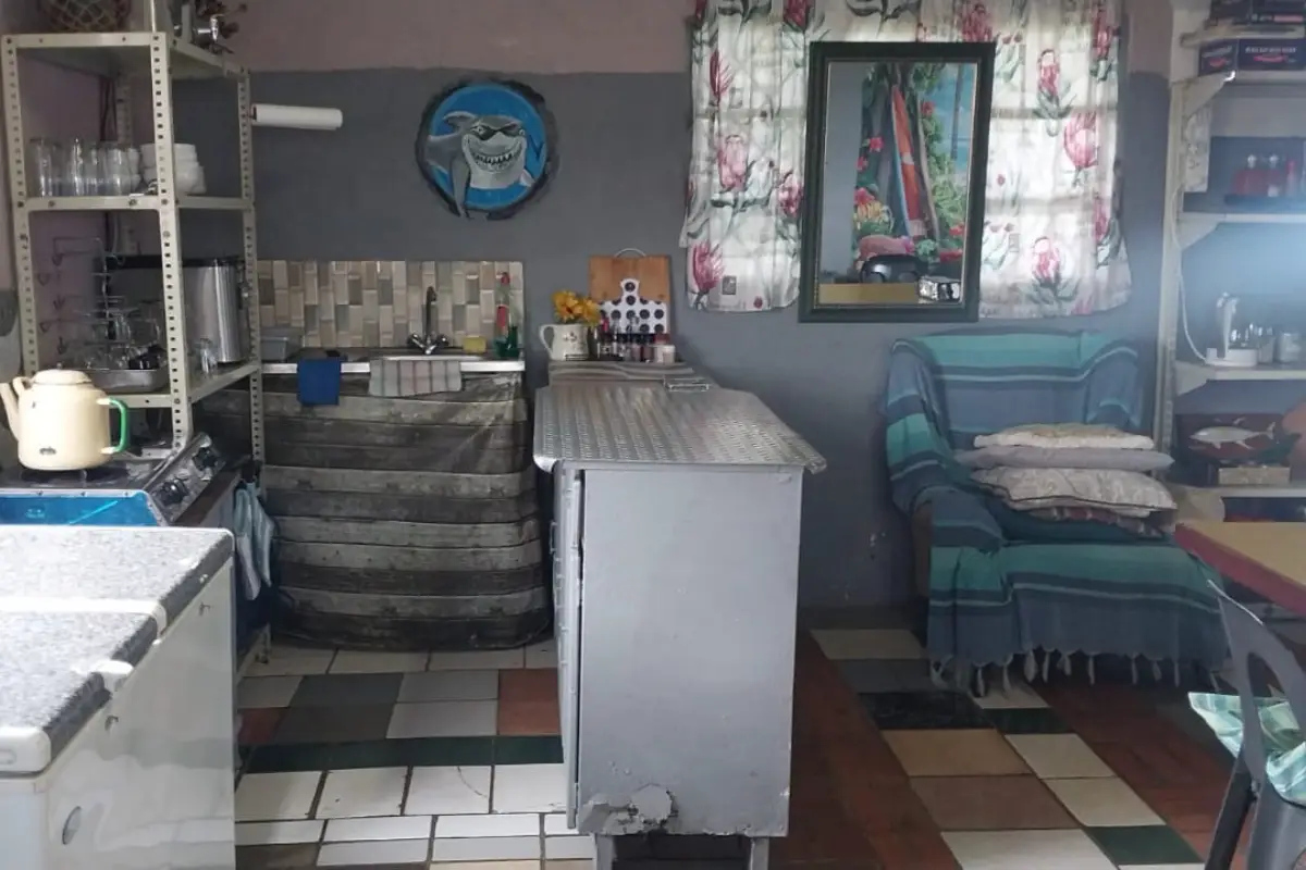 Cosy rustic interior of the Hiking Shack stopover with couch, kettle and eclectic wall decorations on the Wild Coast
