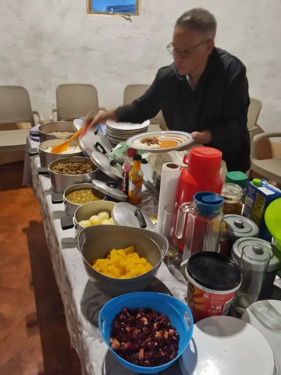 Man serving a generous spread of traditional Xhosa dishes at the Mnyameni homestay, Pondoland Wild Coast