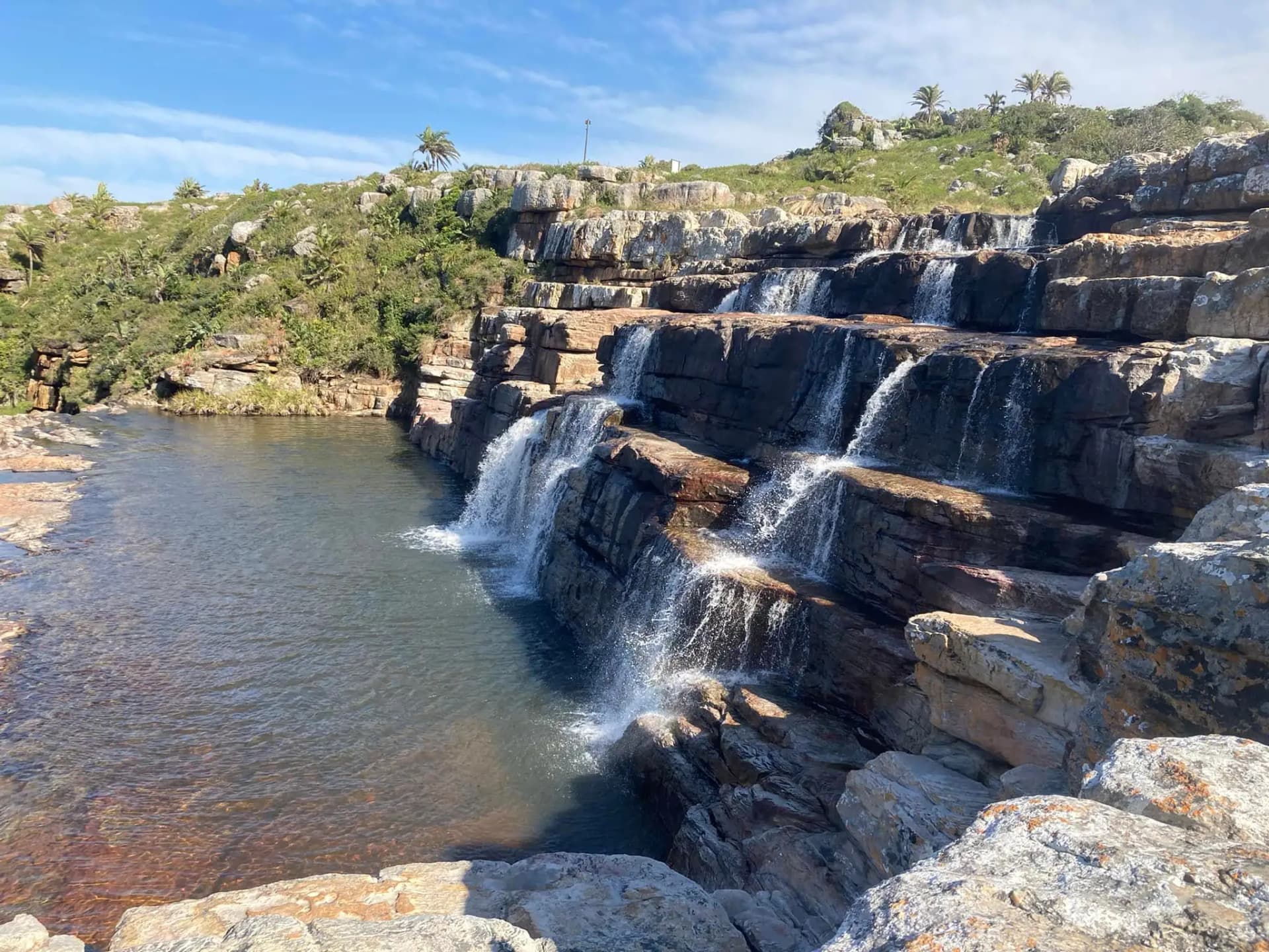 Tiered Mkambathi Falls cascading over flat rock shelves into the natural Jacuzzi Hole pool, Wild Coast