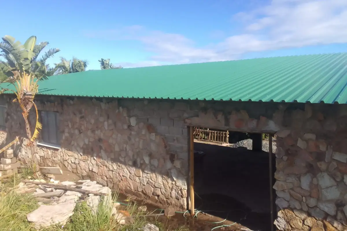 Rebuilt stone building at Mtentu Lodge Wild Coast with new green corrugated iron roof and wooden door