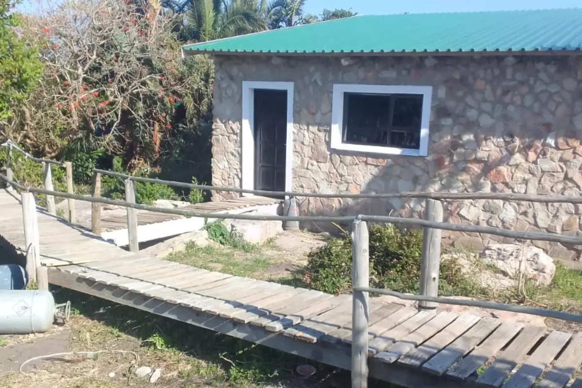 Newly rebuilt stone cabin at Mtentu Lodge with green roof and wooden boardwalk approach on Wild Coast