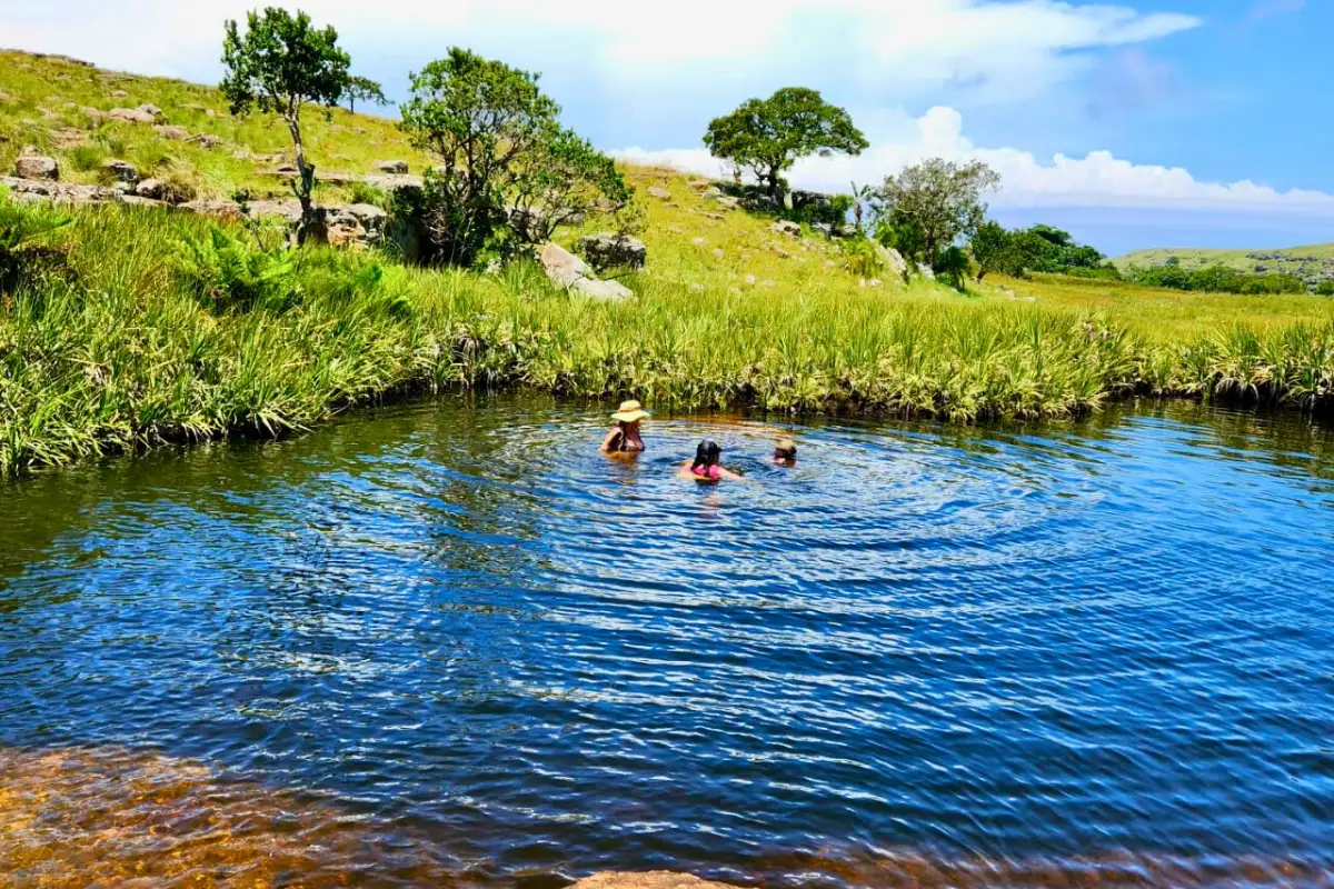 Three swimmers enjoying the Paradise Pool natural freshwater swimming hole on the Mtentu River, Wild Coast