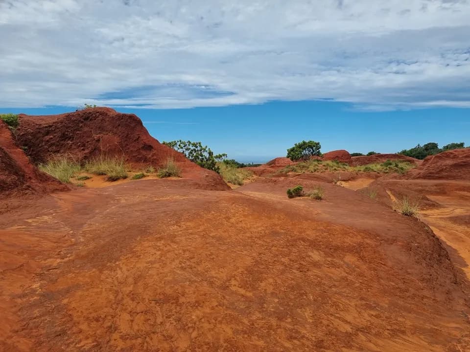Vivid red iron-rich sand dunes beside the Sikombe River under a blue Pondoland sky Wild Coast South Africa