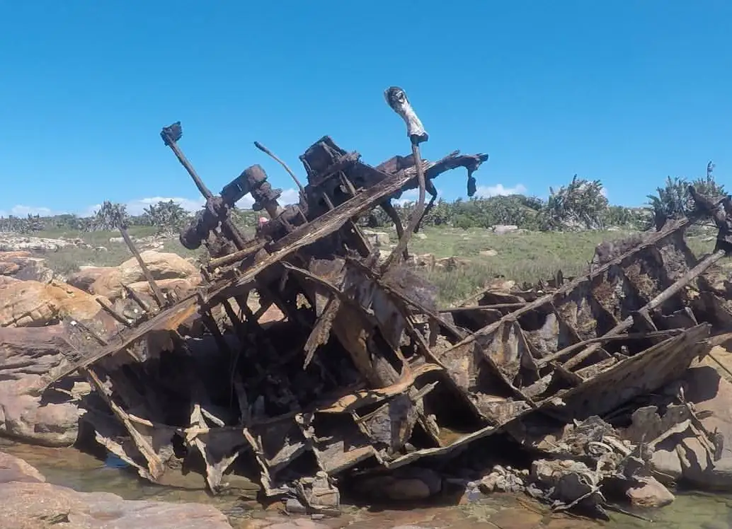 Rusted twisted hull of the Weolmi shipwreck collapsed on rocks at Mkambathi, Wild Coast, Eastern Cape